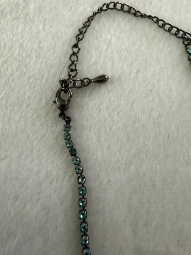 Vintage blue rhinestone bow necklace set in dark antiqued metal.