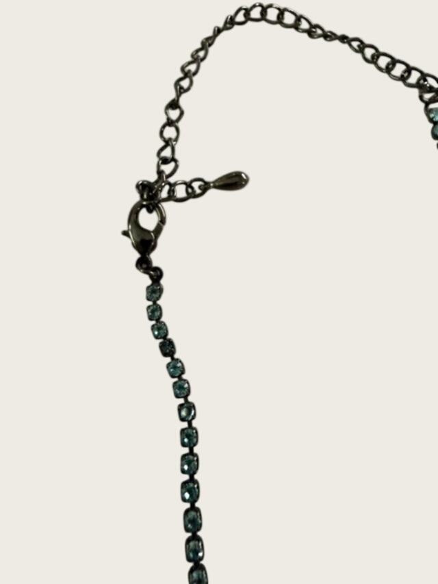 Vintage blue rhinestone bow necklace set in dark antiqued metal.