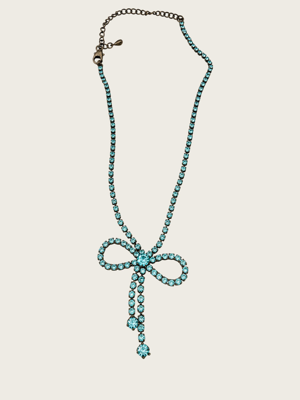 Vintage blue rhinestone bow necklace set in dark antiqued metal.