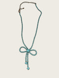 Vintage blue rhinestone bow necklace set in dark antiqued metal.