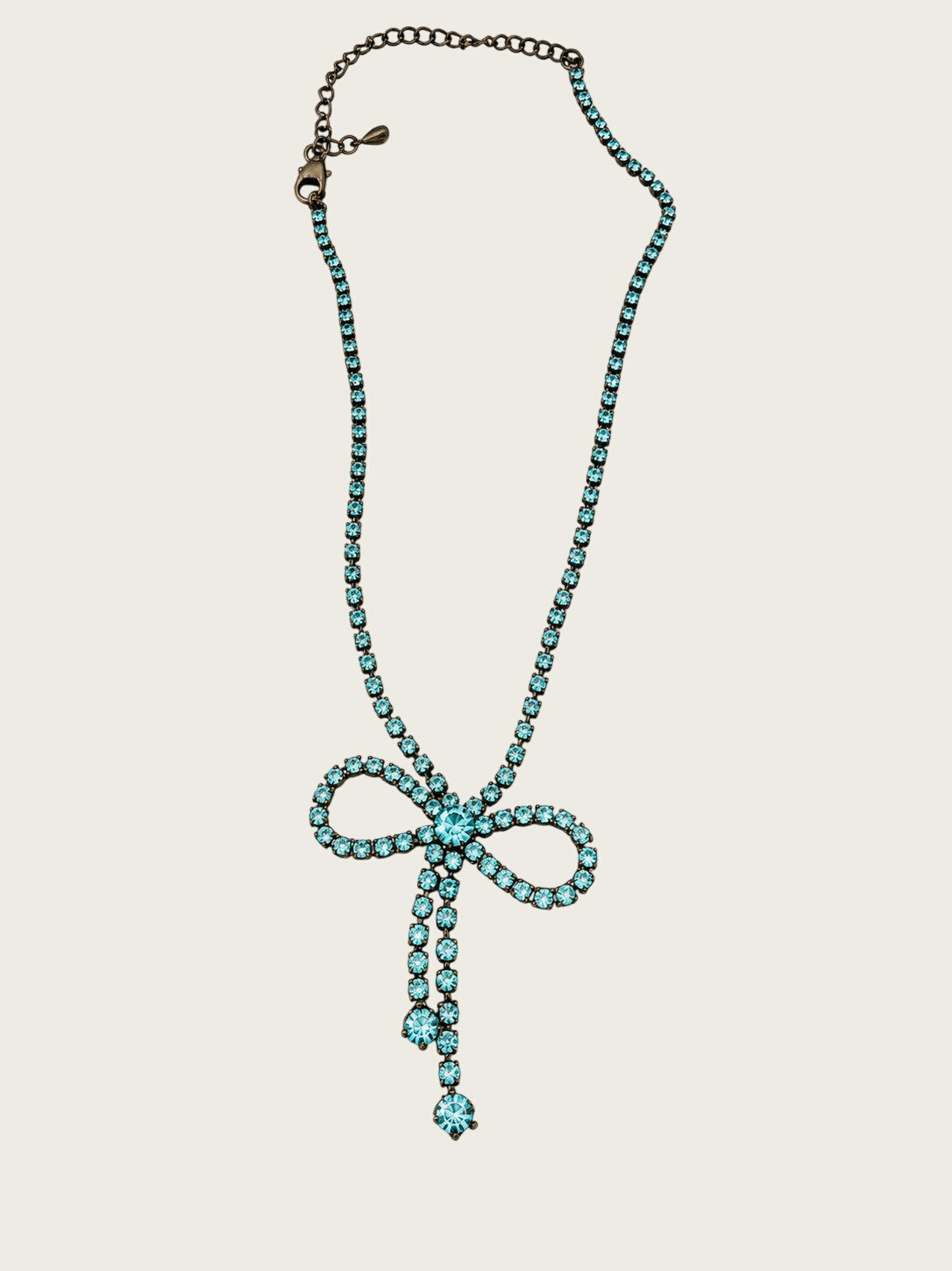 Vintage blue rhinestone bow necklace set in dark antiqued metal.