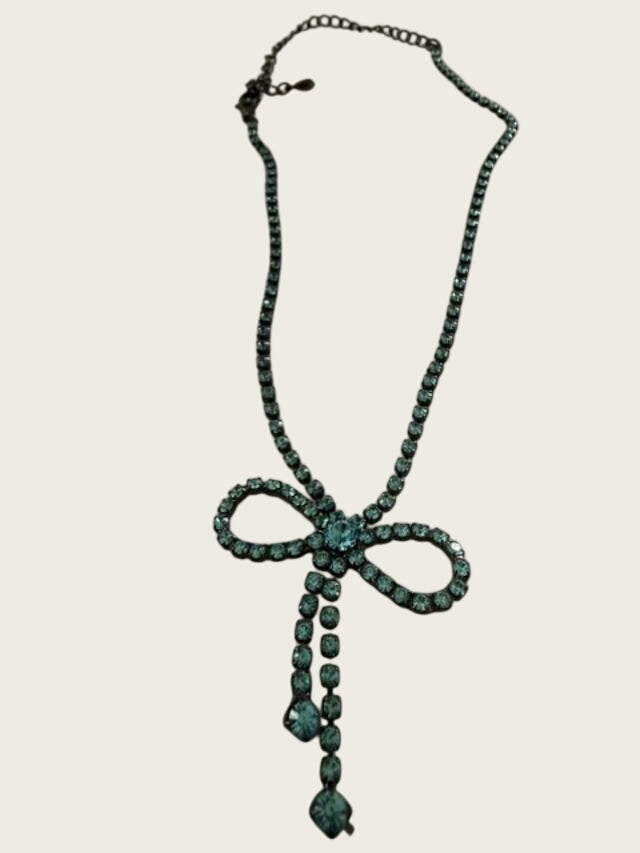 Vintage blue rhinestone bow necklace set in dark antiqued metal.